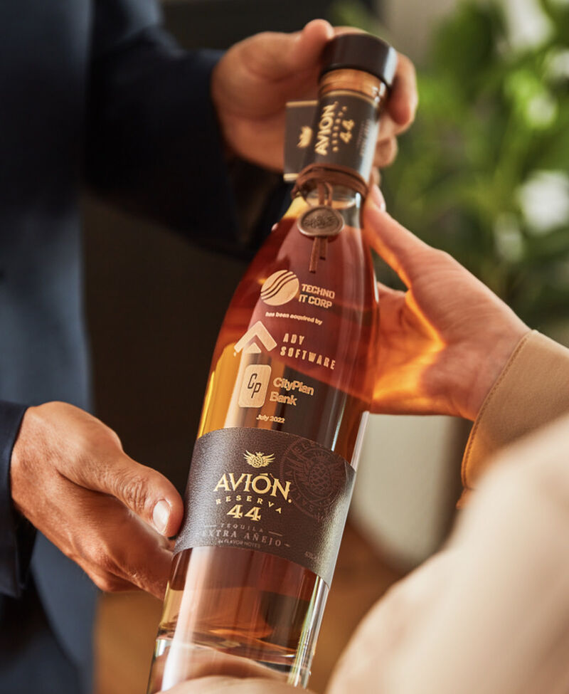 A custom engraved bottle of Avion being given as a corporate gift